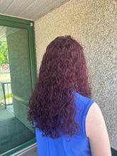 long hair curly perm red violet purple hair cherry cola hair colour 2024 women's hair trending color idea brantford hairstylist hair salon near me affordable services walk in appointments brantford hair cosmetology school college diploma skilled trades registration 